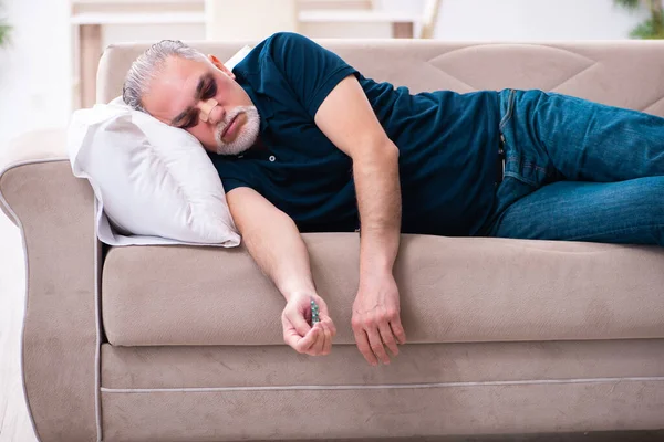 Velho com os olhos feridos descansando em casa — Fotografia de Stock