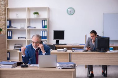 Ofiste çalışan iki erkek çalışan.