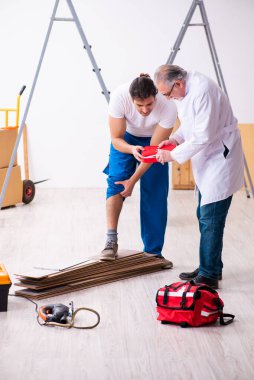 Deneyimli sağlık görevlisi yılan tarafından ısırılan işçiye yardım ediyor.