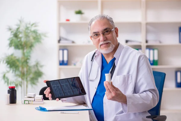 Old male doctor radiologist in telehealth concept