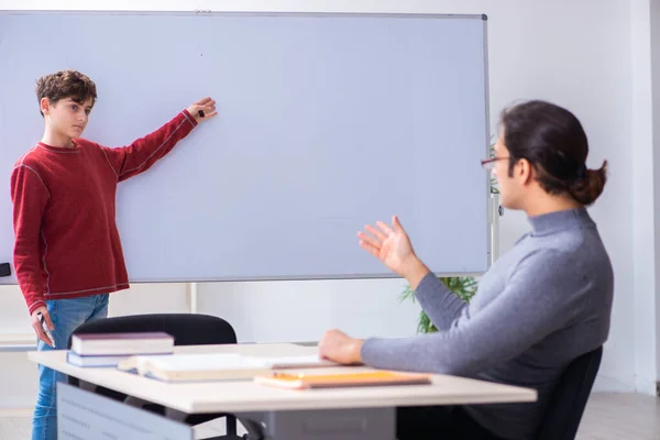 Giovane insegnante e scolaro maschio in classe — Foto Stock