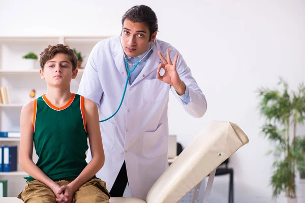 Enfermo niño visitando joven médico pediatra —  Fotos de Stock