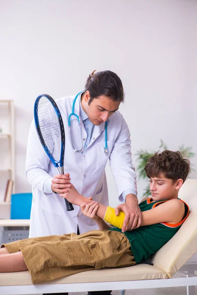 Zieke jongen op bezoek bij jonge mannelijke arts kinderarts — Stockfoto