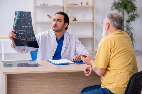 Velho paciente visitando jovem médico radiologista — Fotografia de Stock