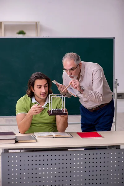 Старый профессор физик и молодой студент в классе — стоковое фото