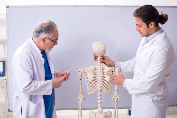 Experienced doctor surgeon teaching young male assistant — Stock Photo, Image