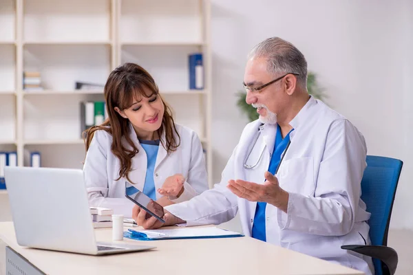 Velho médico radiologista masculino e sua jovem assistente feminina no th — Fotografia de Stock