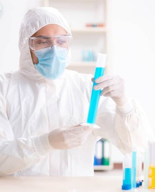 Laboratuvarda kimyasallar üzerinde çalışan genç bir kimyager.