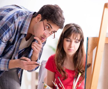 Stüdyoda resim sınıfında sanatçı koçluğu yapan bir öğrenci.