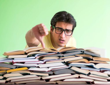 Sınavdan önce okumak için çok fazla kitabı olan öğrenci
