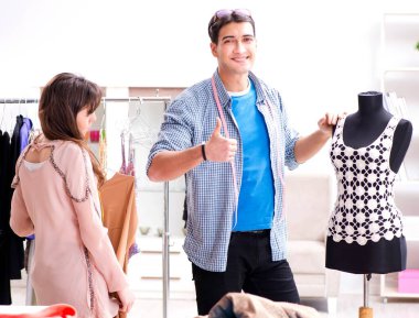 Atölyede erkek terzi ve bayan öğrenci.