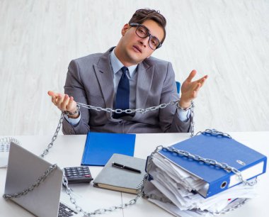 Ofis masasına zincirlenmiş meşgul bir çalışan.