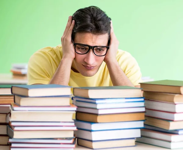 Sınavdan önce okumak için çok fazla kitabı olan öğrenci