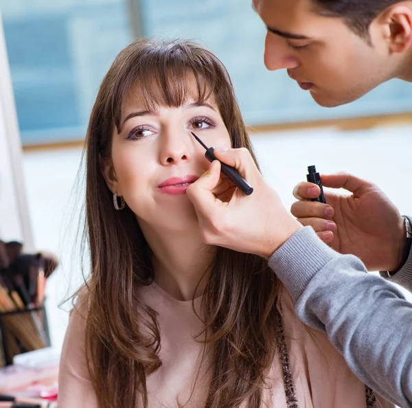 Uomo che fa il make-up per la donna carina nel salone di bellezza — Foto Stock