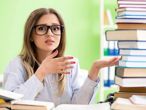 Mladá studentka se připravuje na zkoušky s mnoha knihami — Stock fotografie