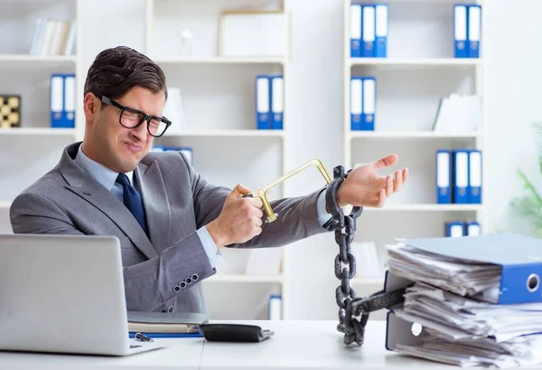 Ofis masasına zincirlenmiş meşgul bir çalışan.