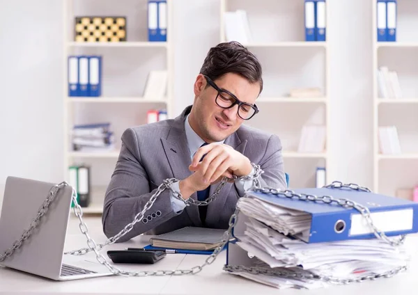 Ofis masasına zincirlenmiş meşgul bir çalışan.