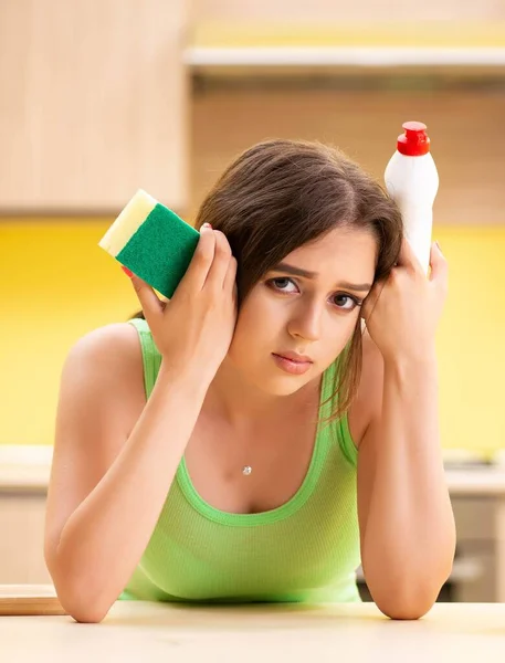 Ung kvinna städa och diska i köket — Stockfoto