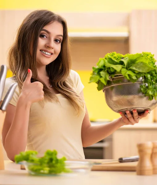 Mladá žena připravuje salát doma v kuchyni — Stock fotografie