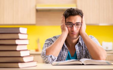 Sınava hazırlanan öğrenci mutfakta oturuyor.