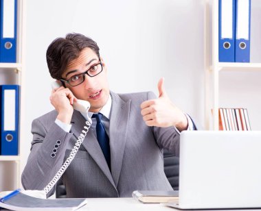 İşadamı ofis telefonundan konuşuyor.