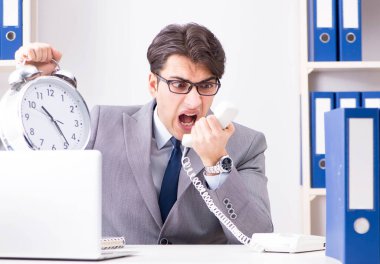 Acil ve son teslim tarihi konseptinde alarm veren bir işadamı.