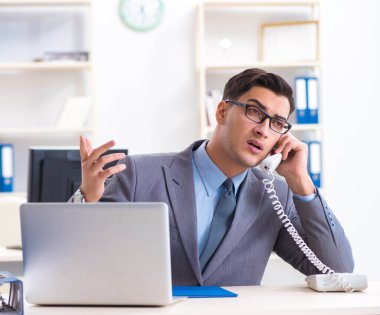 Ofisteki masasında oturan yakışıklı bir işadamı.