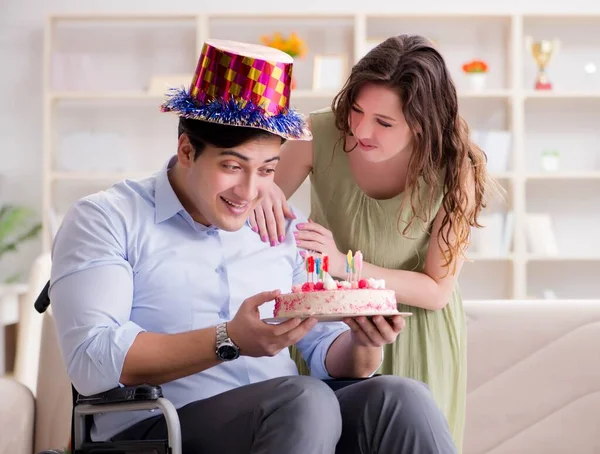 Joven familia celebrando cumpleaños con persona discapacitada —  Fotos de Stock