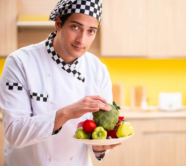 Jovem cozinheiro profissional preparando salada em casa — Fotografia de Stock