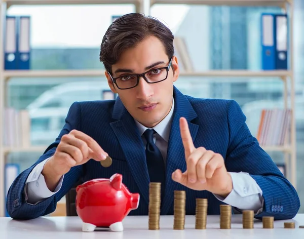 Empresario con pilas de monedas en la oficina —  Fotos de Stock