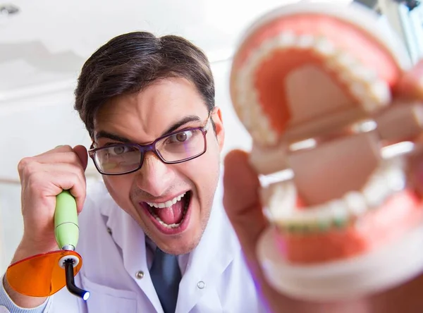 Divertente dentista con la cura della luce nel concetto medico — Foto Stock