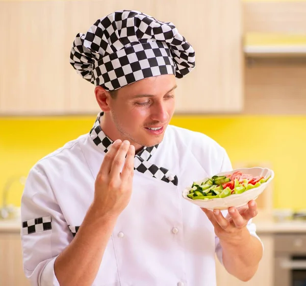 Mladý profesionální kuchař připravuje salát v kuchyni — Stock fotografie
