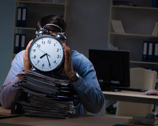 Jovem empregado que trabalha horas extras para cumprir prazo — Fotografia de Stock