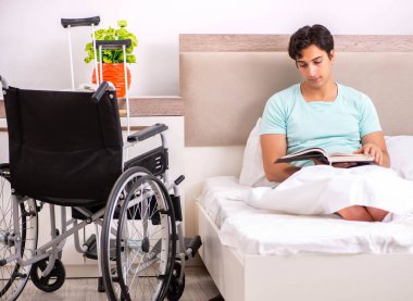 Genç yakışıklı engelli adam evde iyileşiyor.