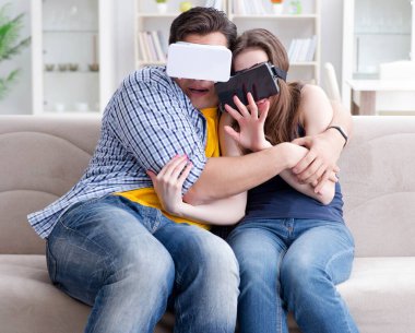 Genç bir aile sanal gerçeklik gözlükleriyle oyun oynuyor.