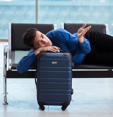 Havaalanı dinlenme odasında yolcu bekleyen adam.