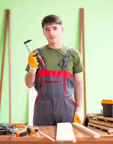 Ácsmunkás fiatalember műhelyben — Stock Fotó