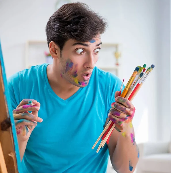 Joven artista divertido trabajando en la nueva pintura en su estudio — Foto de Stock