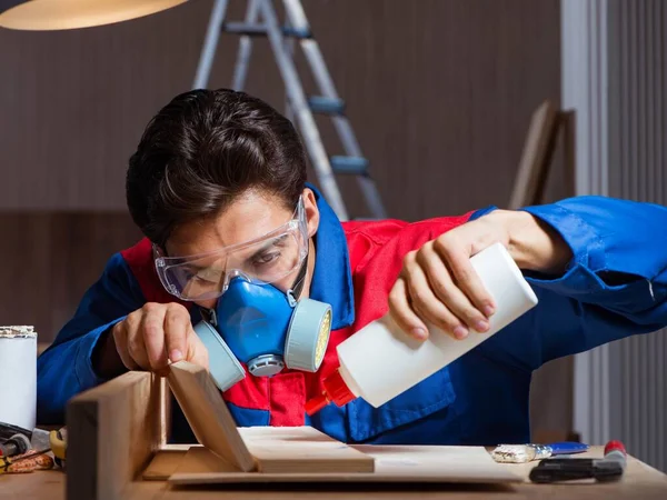 Genç adam ahşap parçaları DIY konseptinde yapıştırıyor.