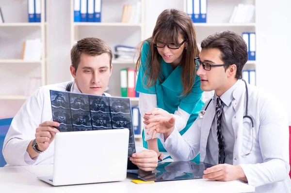 Tres médicos discutiendo los resultados de la exploración de la imagen de rayos X — Foto de Stock