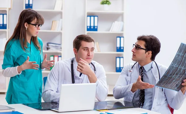 Tres médicos discutiendo los resultados de la exploración de la imagen de rayos X — Foto de Stock