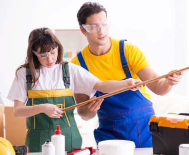 Ahşap atölyesinde kadın marangozluk ipuçlarını açıklayan adam