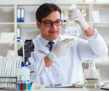 Genç araştırmacı bilim adamı bir su testi kirliliği araştırması yapıyor.