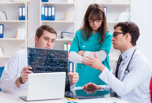 Tres médicos discutiendo los resultados de la exploración de la imagen de rayos X — Foto de Stock