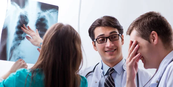 Három orvos tárgyalja a röntgenkép eredményeit. — Stock Fotó
