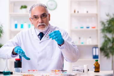 Laboratuvarda çalışan yaşlı bir kimyager.