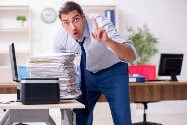 Kopyalama makinesinde çalışan genç bir erkek.