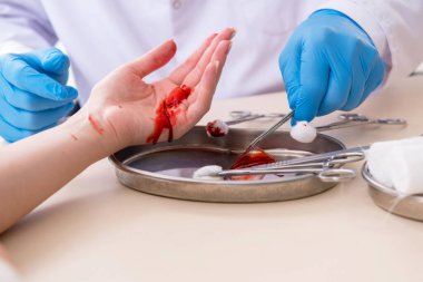 Yaralı kadın erkek doktoru ziyaret ediyor.