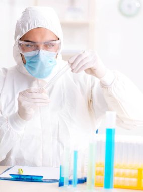 Laboratuvarda kimyasallar üzerinde çalışan genç bir kimyager.