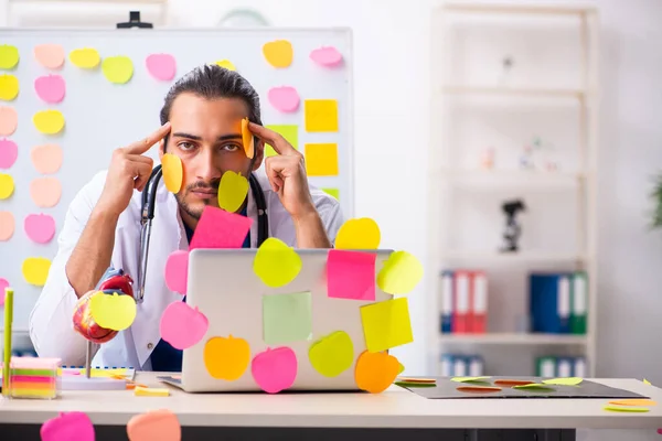 Young male medic in conflicting priorities concept — Stock Photo, Image